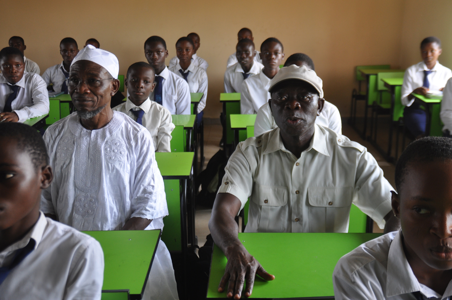 Governor Adams Oshiomhole of Edo State (right) and his Osun State counterpart, Ogbeni Rauf Aregbesola sit with students in one of the classrooms of the rebuilt Asoro Grammar School, Benin City, after the commissioning of the school on Friday.
