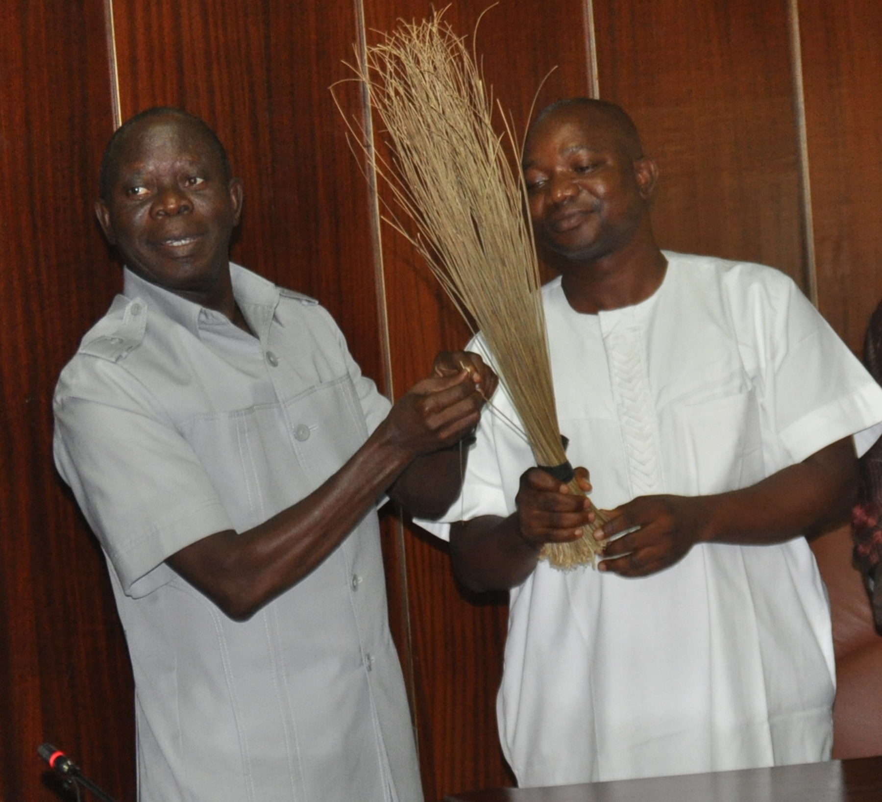 Governor Adams Oshiomhole of Edo State hands a broom, the symbol of the All Progressives Congress (APC), to Mr Saturday Owulekhue, former Chairman, Orhiomwon Local Government Area after his decamping to the APC, on Saturday.