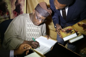 The author, Olusegun Obasanjo signs autograph at the book unveiling