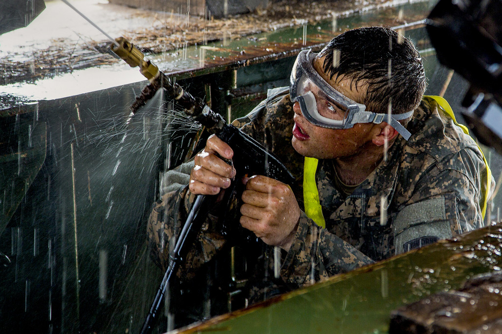 U.S. Army Spc. Michael Saucier pressure washes the bottom of a tactical vehicle in Buchanan, Liberia, Jan. 28, 2015. Soldiers are required to wash military vehicles before they return to the United States. Saucier is a truck driver assigned to the 101st Sustainment Brigade, Task Force Lifeliner, Joint Forces Command United Assistance. 