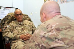 Lt. Cmdr. Mahmoud Ahmed, a Navy psychiatrist, left, speaks with a patient at the NATO Role 3 Multinational Medical Unit on Kandahar Airfield, Afghanistan. U.S. Navy photo by Lt. Cmdr. Jesse Ehrenfeld