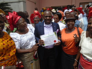 Matthew Urhoghide,Edo South Senator-elect,displaying his INEC certificate of return for party supporters in Benin City.
