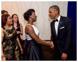 An elated Precious Osagie-Erese in a warm handshake with  President Barrack Obama.