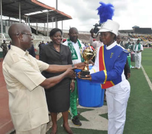 Governor Adams Oshiomhole of Edo State presents the 2nd prize trophy to a student of University Preparatory Secondary School, Benin Cit