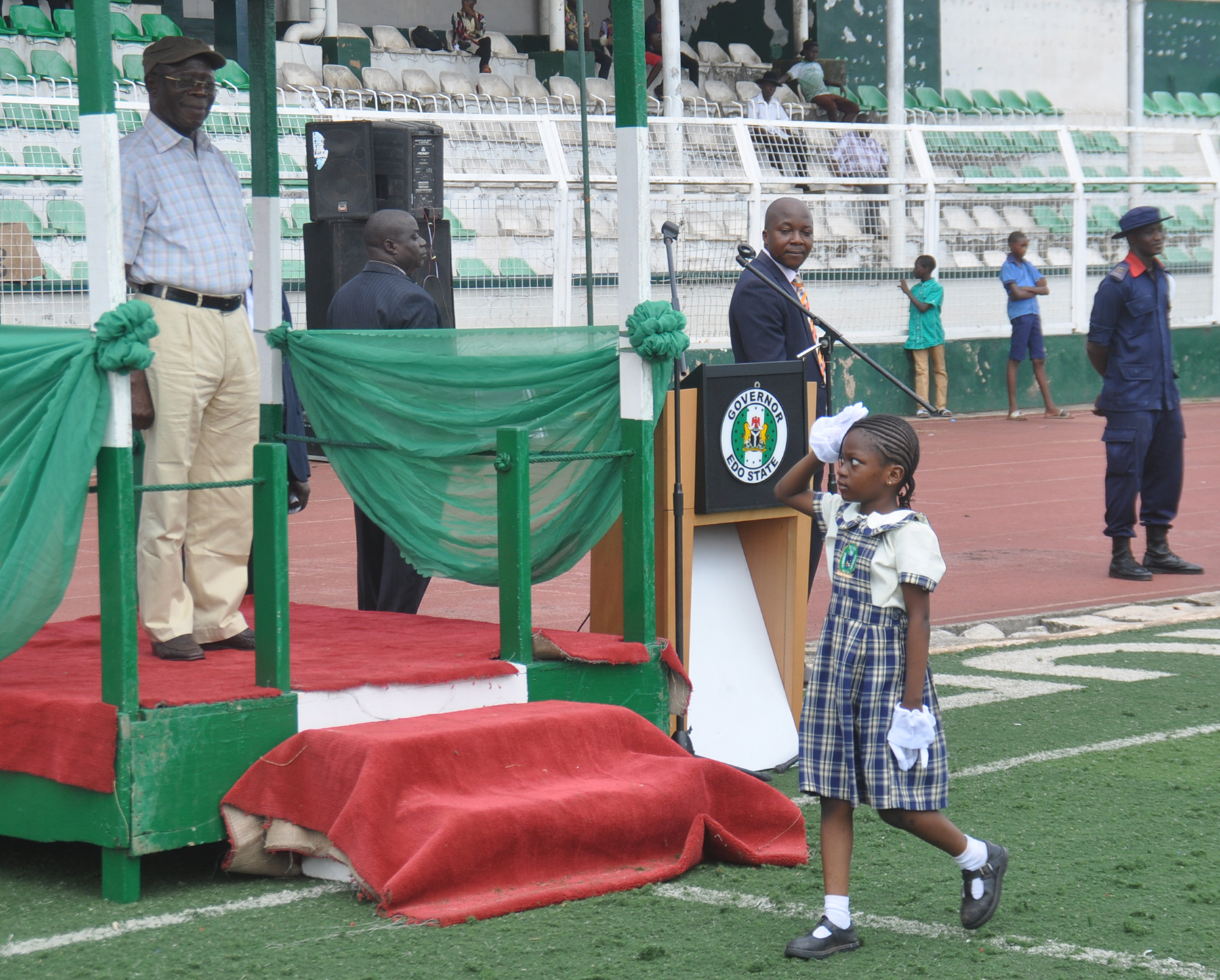 A pupil of Flourish Royal Academy, Benin City salutes Governor Adams Oshiomhole during a march past at the 2016 Children's Day celebration in Benin City on Friday.