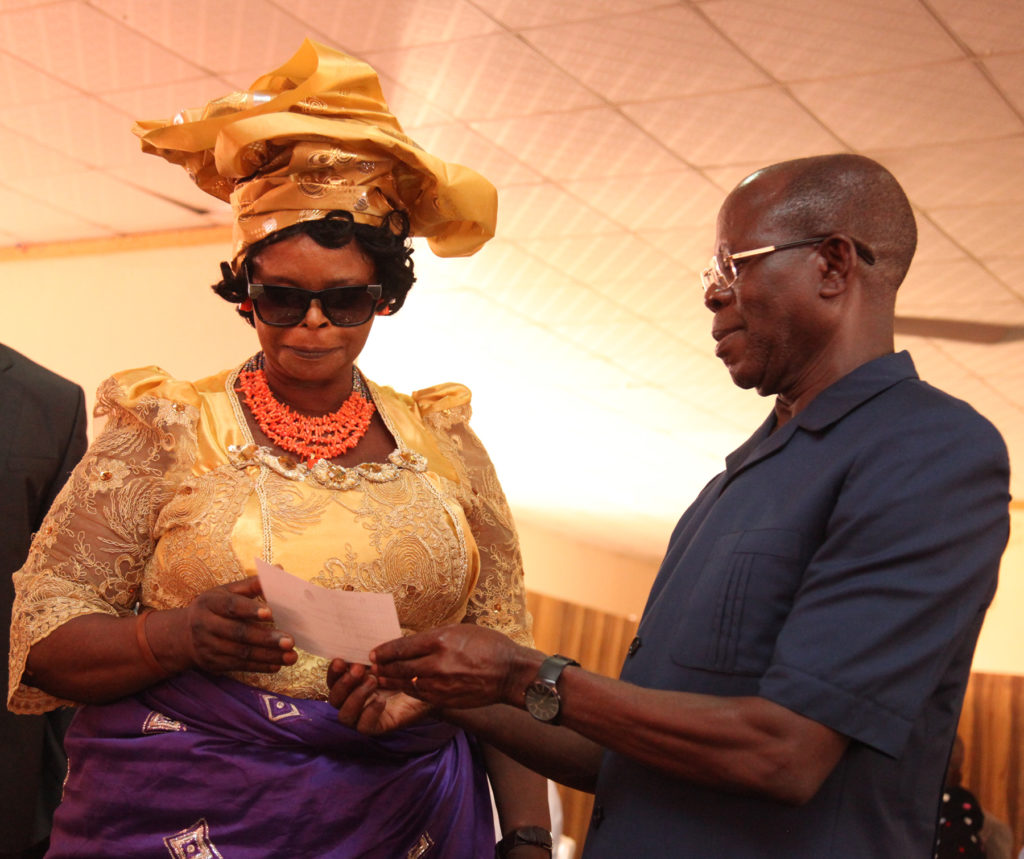 Mrs Rita Enaholo of God First Quintessential Women receives a cheque from Governor Adams Oshiomhole on behalf of the group at the disbursement of N2 billion Micro, Small and Medium Enterprise Development Fund (MSMEDF), by the state Government, on Monday.