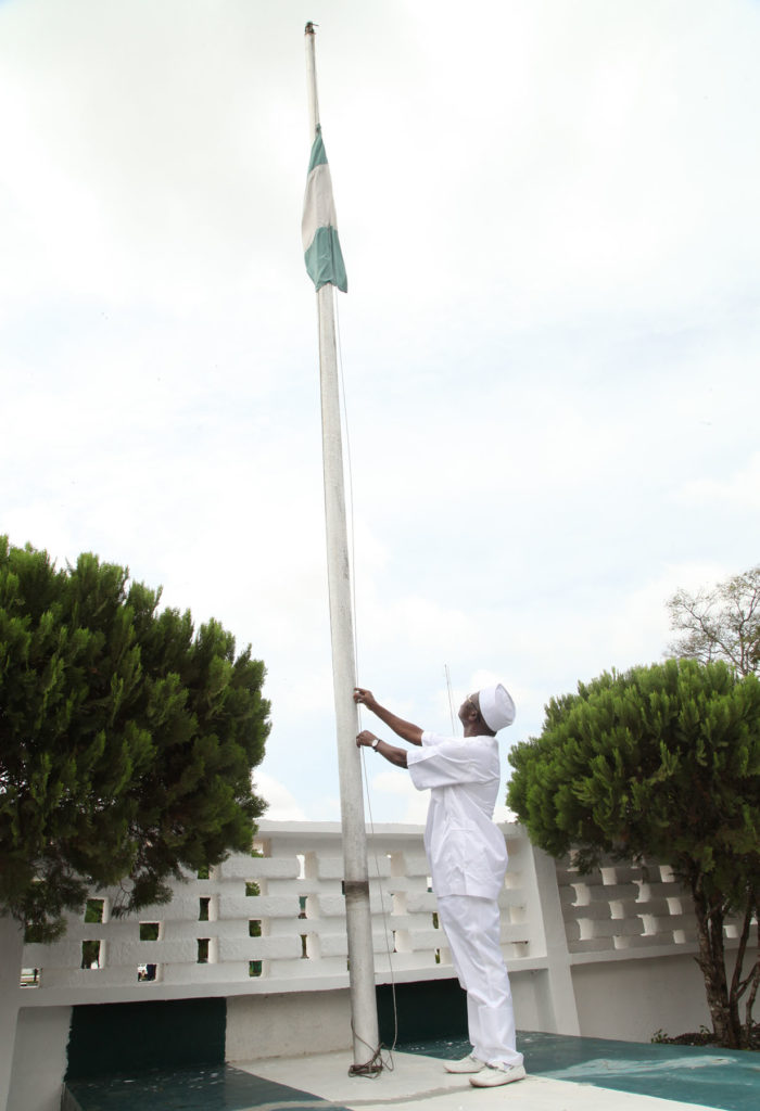 Governor Adams Oshiomhole of Edo State lowers the Nigerian flag to half mast at the Government House, Tuesday, in honour of the Oba of Benin, Oba Erediauwa, whose transition to immortality was announced last week.
