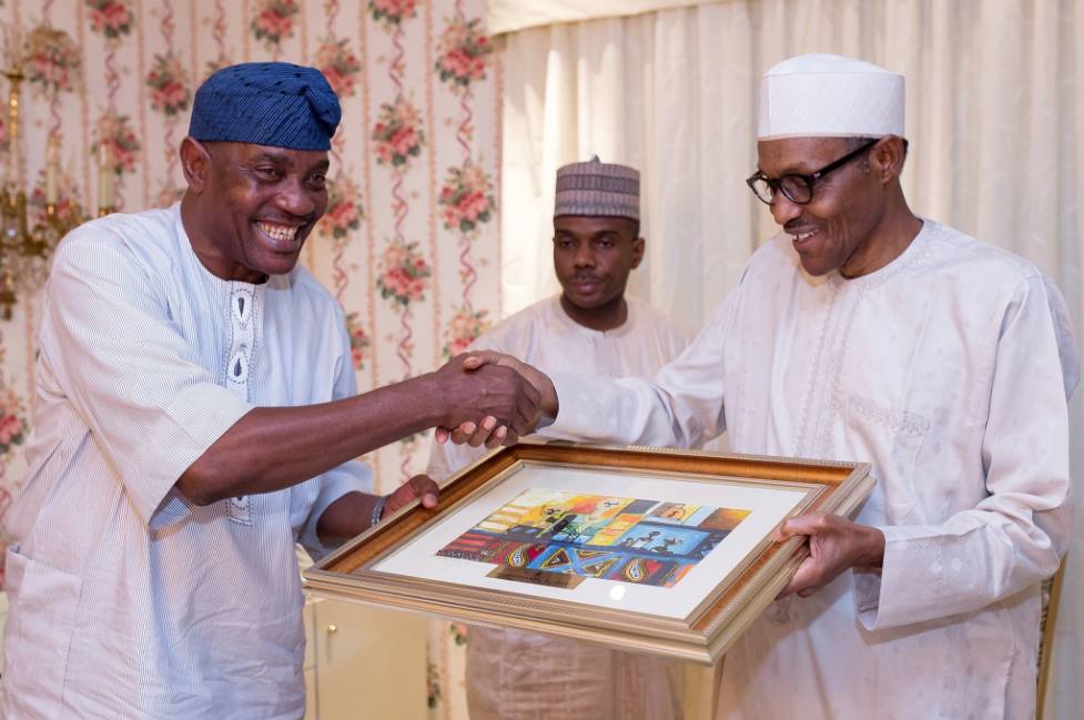 e‬ President Buhari presenting a gift to Outgoing Inspector General of Police IG Solomon Arase