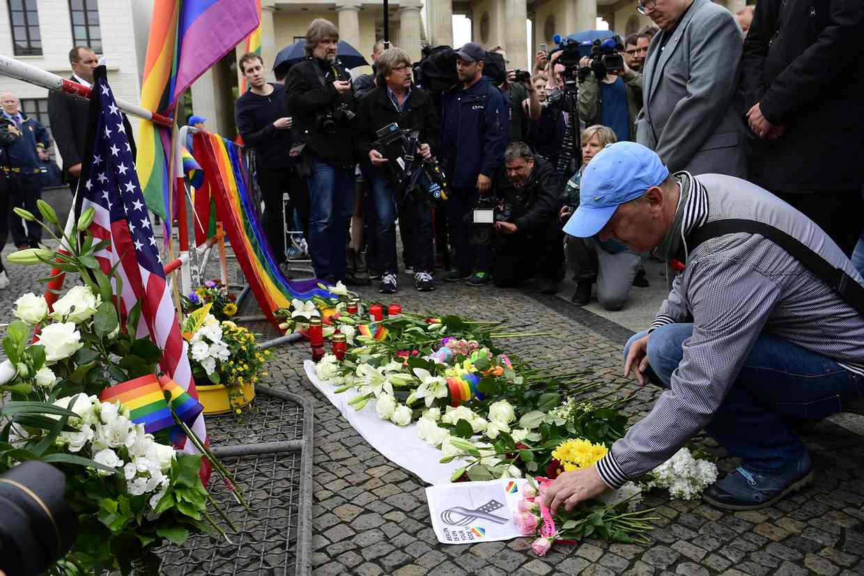  A man disposes roses on the ground in front of the US Embassy in Berlin. Photograph: John Macdougall/AFP/Getty Image